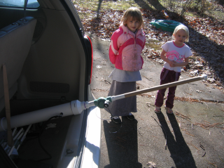 Kids looking slightly worried over the assembled PVC air cannon.